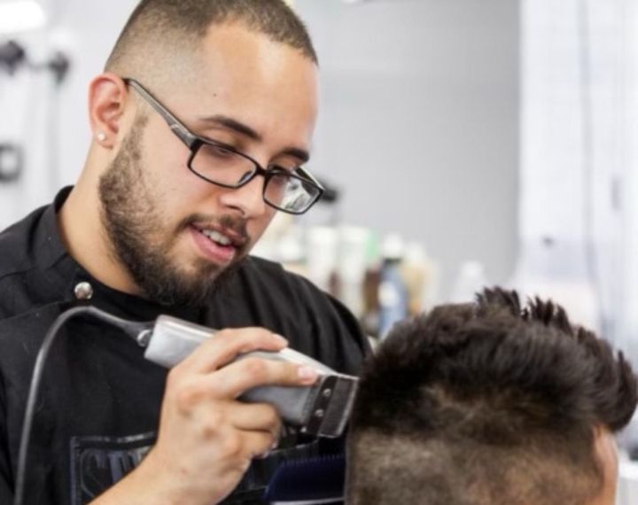 man with a fresh haircut adjusting the collar of his shirt